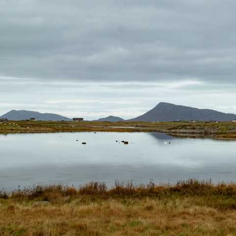 A loch, with hills in the distances from other nearby islands. 